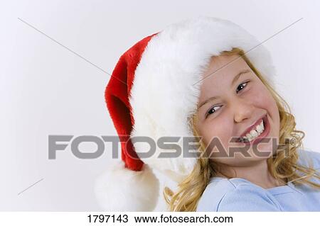 Stock Image - Young girl wearing Santa hat. Fotosearch