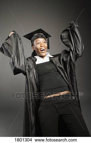 Picture - Young woman rejoicing in graduation cap and gown. Fotosearch