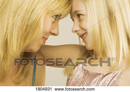 Stock Image - A mother and daughter putting their heads together. Fotosearch