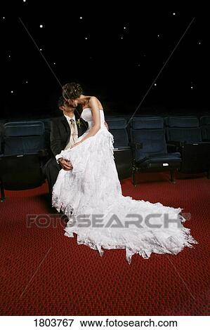 Stock Photo - A newlywed couple kissing indoors. Fotosearch