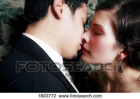 Stock Image - A newlywed couple kissing. Fotosearch