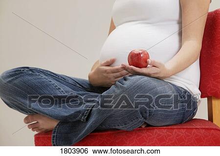 A pregnant woman holding apple View Large Photo Image Stock Photograph - A pregnant woman holding apple. Fotosearch