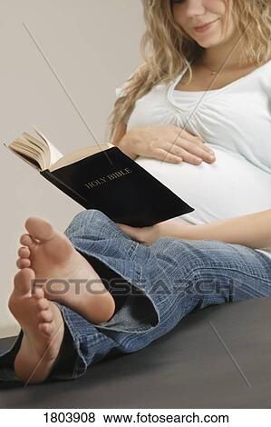 Stock Photo - A pregnant woman reading the Bible. Fotosearch
