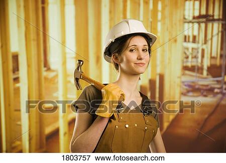 A woman smiling and holding a hammer View Large Photo Image Stock Photo - A woman smiling and holding a hammer. Fotosearch