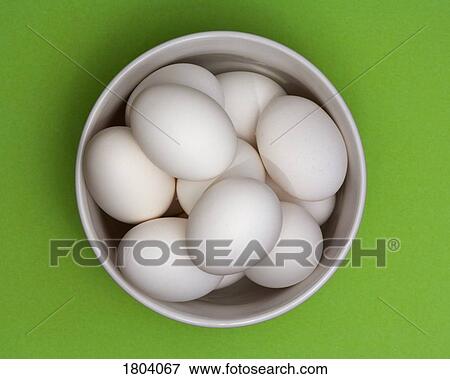 Stock Photo - Bowl of eggs with green background. Fotosearch