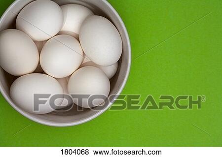 Bowl of eggs with green background View Large Photo Image Stock Photo - Bowl of eggs with green background. Fotosearch