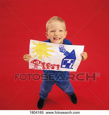 Stock Photography - Boy posing for the camera shot while holding a painting. Fotosearch