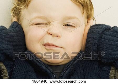 Stock Image - Boy with his hands over his ears. Fotosearch