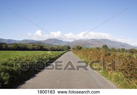 Stock Image - Country Road & Comeragh Mountains, Near Mahon Bridge, Co Waterford, Ireland. Fotosearch
