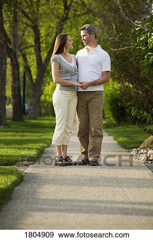 Stock Photo - Couple standing on sidewalk. Fotosearch