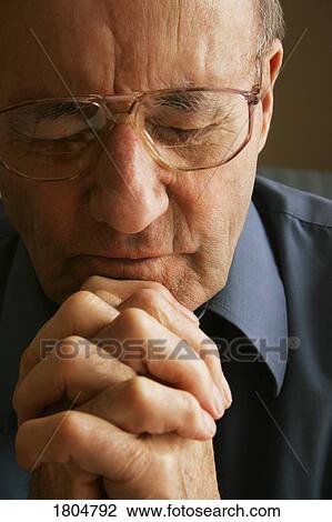 Stock Image - Elderly man praying. Fotosearch