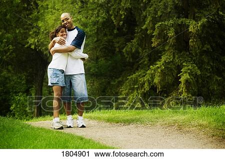 Stock Image - Father and daughter walking along a path. Fotosearch