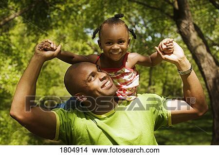 Picture - Father carrying daughter on shoulders. Fotosearch