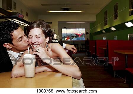 Stock Photo - Front view of a couple drinking in a restaurant. Fotosearch