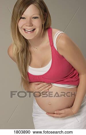 Front view of a pregnant woman laughing View Large Photo Image Stock Image - Front view of a pregnant woman laughing. Fotosearch