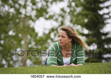 Stock Photo - Front view of a woman laying on lawn. Fotosearch