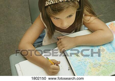 Stock Image - Girl doing work at her desk . Fotosearch