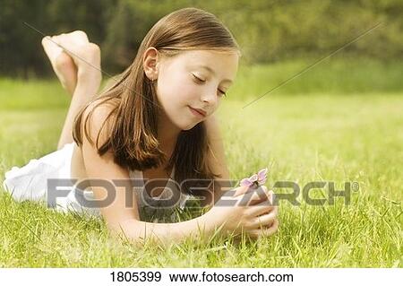 Girl holding a flower View Large Photo Image Stock Photo - Girl holding a flower. Fotosearch