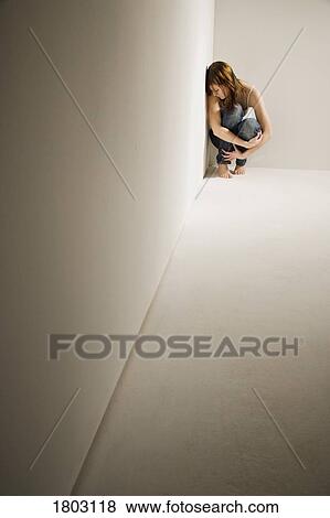 Stock Photo - Girl huddled in corner. Fotosearch
