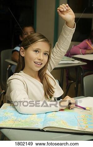 Girl raising her hand in a classroom View Large Photo Image Stock Photo - Girl raising her hand in a classroom. Fotosearch