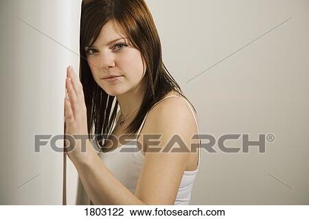 Stock Image - Girl standing against a wall. Fotosearch