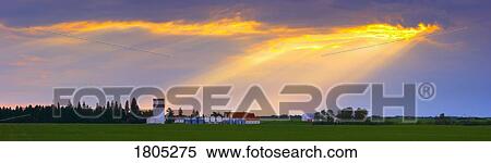 Stock Photography - God beams over prairie farm . Fotosearch