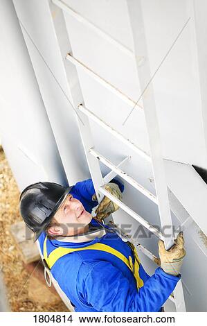High angle view of a worker climbing a ladder View Large Photo Image Picture - High angle view of a worker climbing a ladder. Fotosearch