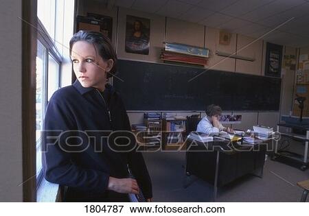 High school student standing by window in classroom View Large Photo Image Stock Photo - High school student standing by window in classroom. Fotosearch