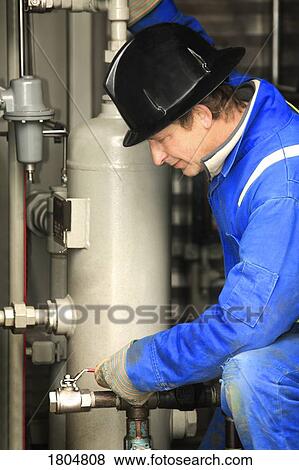 Industrial worker adjusting equipment View Large Photo Image Stock Photo - Industrial worker adjusting equipment. Fotosearch