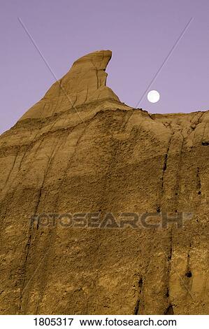 Stock Photo - Low angle view of hoodoo and moon. Fotosearch