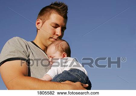 Stock Image - Man holding a baby. Fotosearch