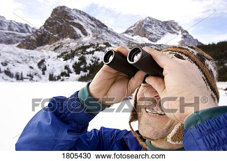Man looking through binoculars View Large Photo Image Stock Image - Man looking through binoculars. Fotosearch