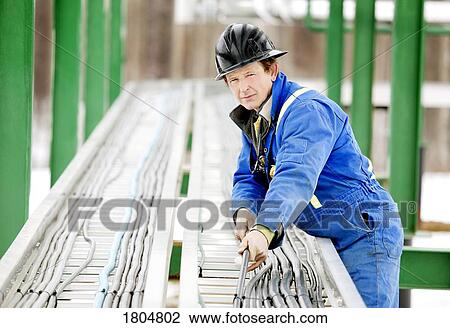 Man working on oilfield machinery View Large Photo Image Stock Image - Man working on oilfield machinery. Fotosearch