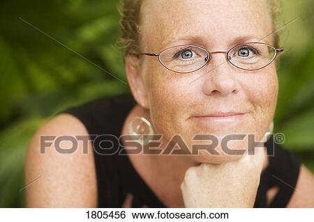 Stock Photograph - Mid adult woman smiling and posing for picture. Fotosearch