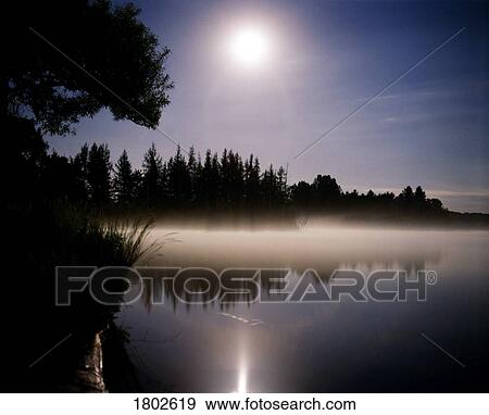 Stock Photo - Moonlight on misty lake . Fotosearch