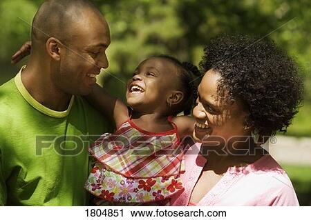 Stock Image - Mother and father laughing with daughter. Fotosearch