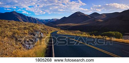 Stock Photo - Panoramic view of foothills road with mountains . Fotosearch