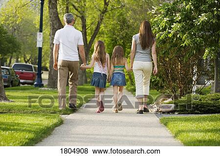 Rear view of family walking on sidewalk View Large Photo Image Stock Photo - Rear view of family walking on sidewalk. Fotosearch