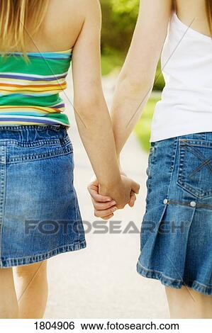 Rear view of girls holding hands View Large Photo Image Stock Photograph - Rear view of girls holding hands. Fotosearch