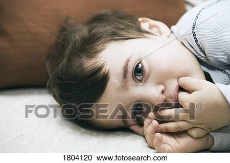 Sad toddler lying down View Large Photo Image Stock Image - Sad toddler lying down. Fotosearch