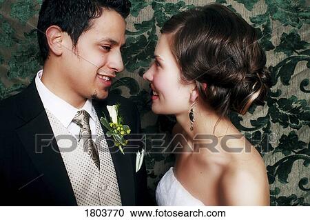 Side view of a couple smiling and looking at each other View Large Photo Image Stock Image - Side view of a couple smiling and looking at each other. Fotosearch