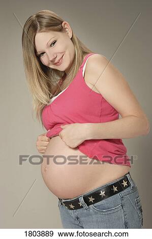 Side view of a pregnant woman looking at the camera View Large Photo Image Stock Photo - Side view of a pregnant woman looking at the camera. Fotosearch