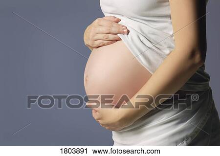 Stock Image - Side view of a pregnant woman. Fotosearch