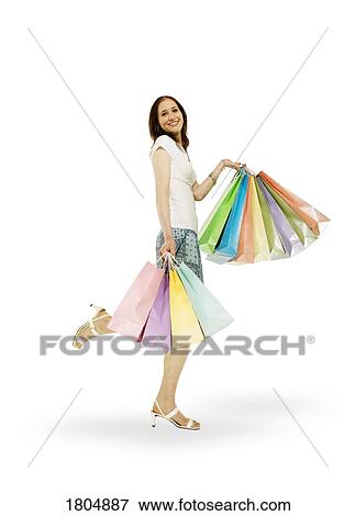 Side view of a woman holding shopping bags View Large Photo Image Stock Photo - Side view of a woman holding shopping bags. Fotosearch
