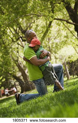 Side view of father hugging son View Large Photo Image Stock Image - Side view of father hugging son. Fotosearch