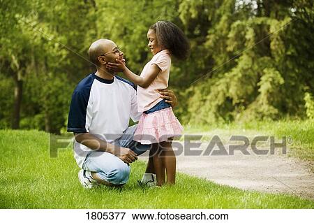 Side view of father with daughter in park View Large Photo Image Stock Photo - Side view of father with daughter in park. Fotosearch