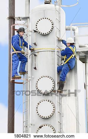 Side view of two industrial workers at work View Large Photo Image Stock Image - Side view of two industrial workers at work. Fotosearch