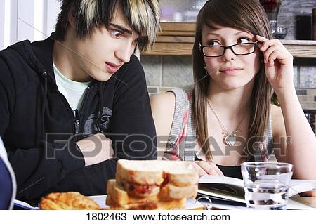 Stock Image - Sister helping her brother with homework. Fotosearch