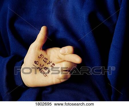 Stock Photography - Student cheating with answers written on the palm of his hand. Fotosearch