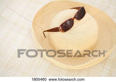 Sunglasses placed on top of sun hat View Large Photo Image Stock Image - Sunglasses placed on top of sun hat. Fotosearch